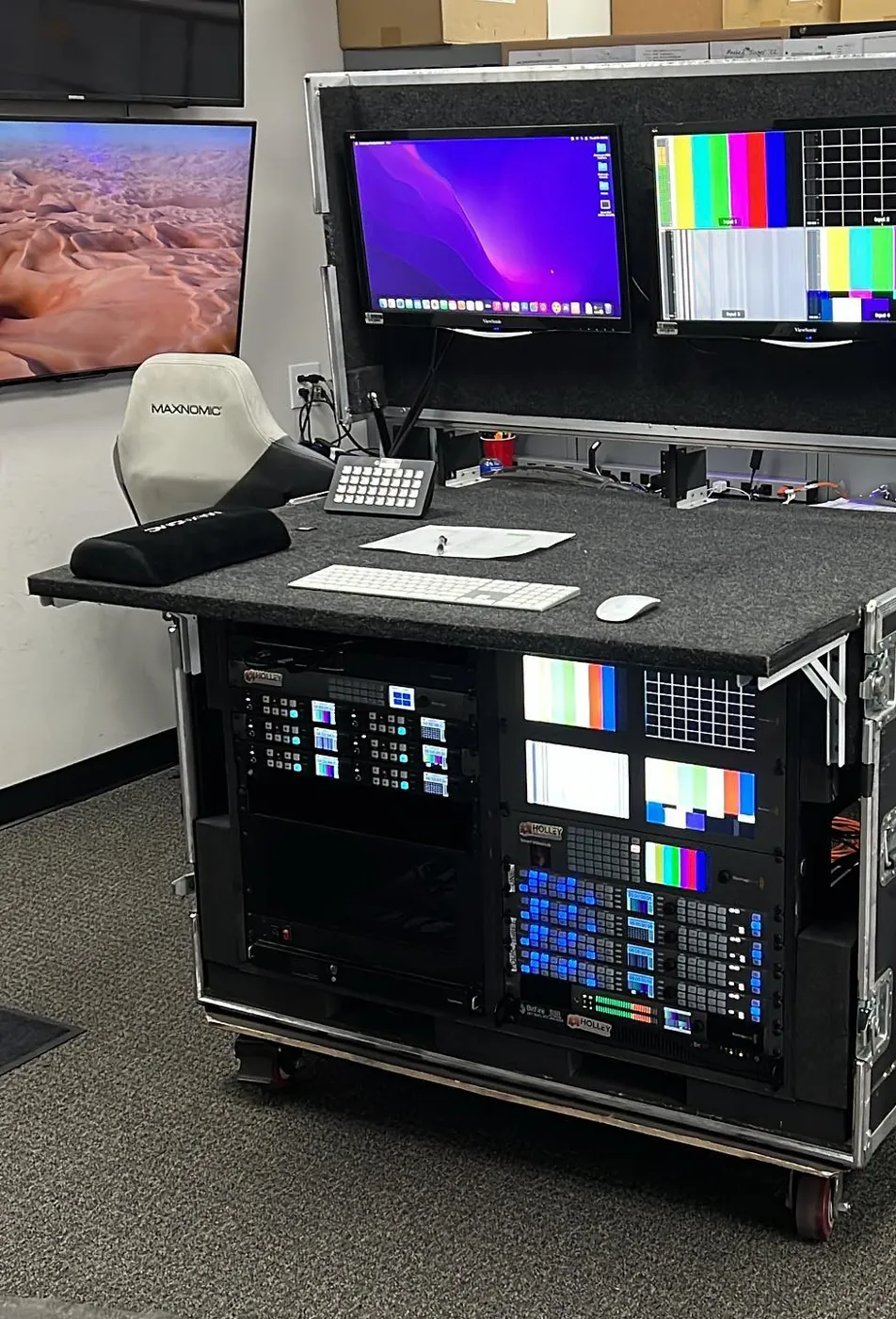 Holley Video flypack desk with dual monitors and rack of routing and record gear
