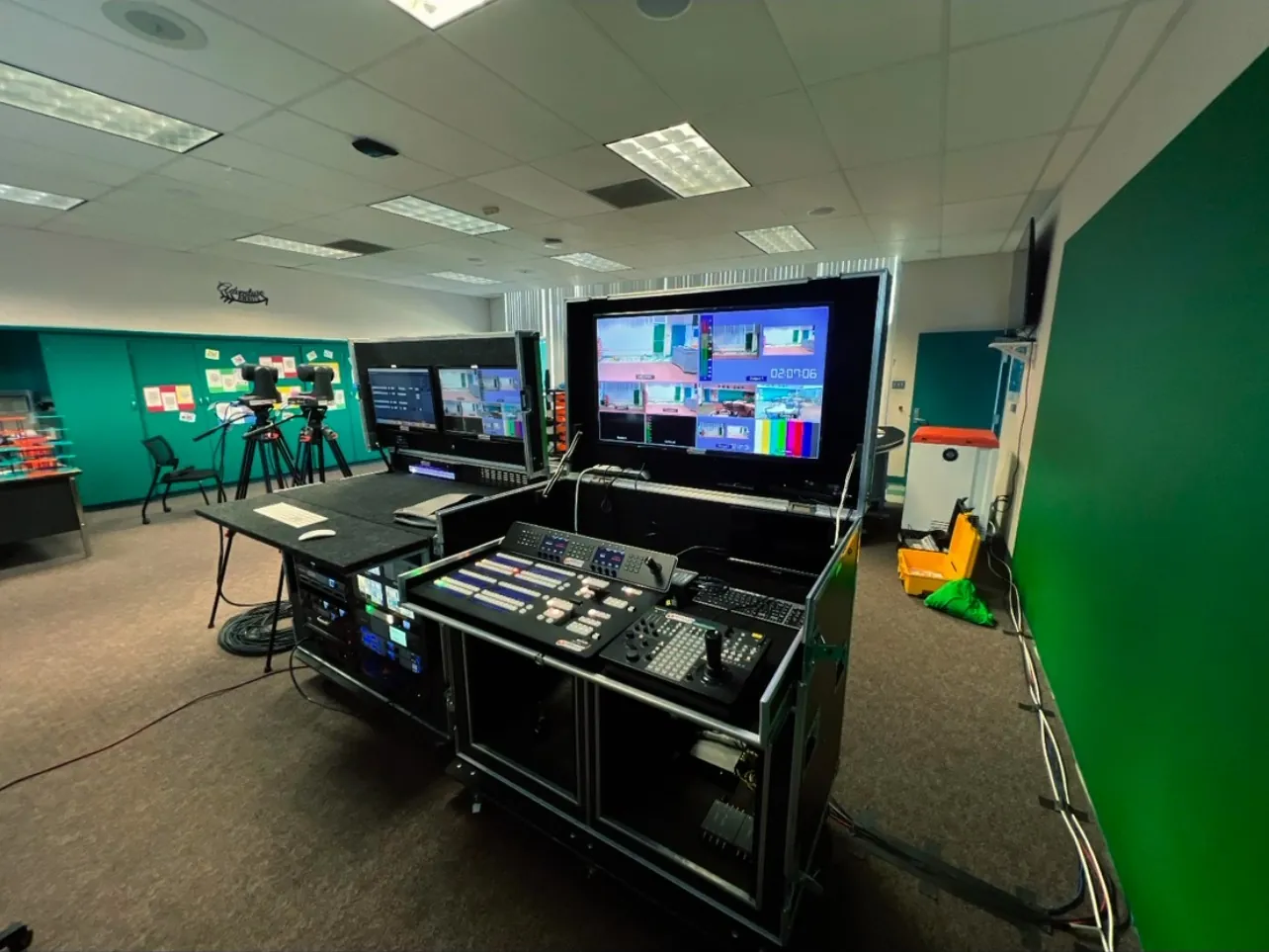 A flypack control station set up beside a green screen stage