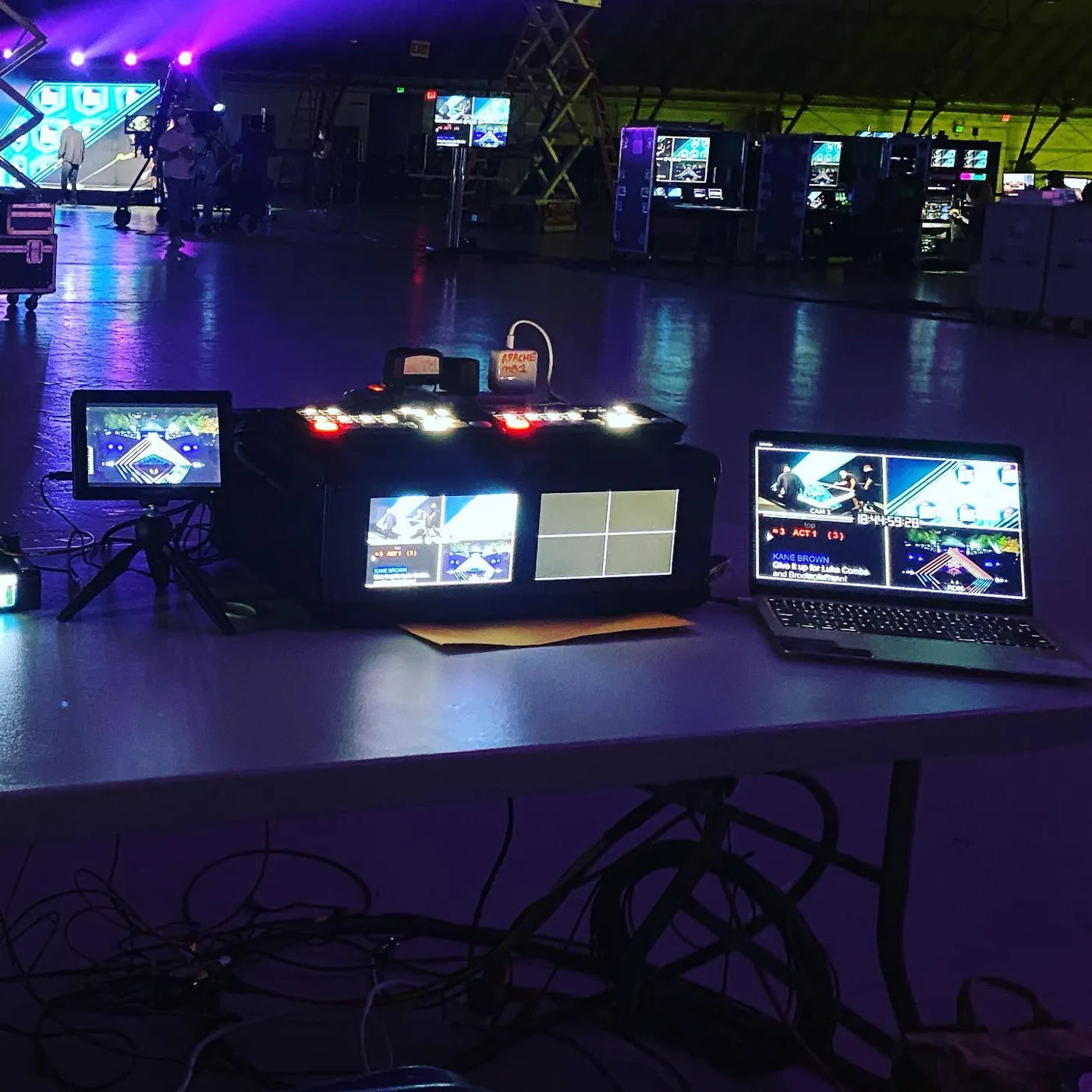 Switcher rig on a stage floor under purple show lights