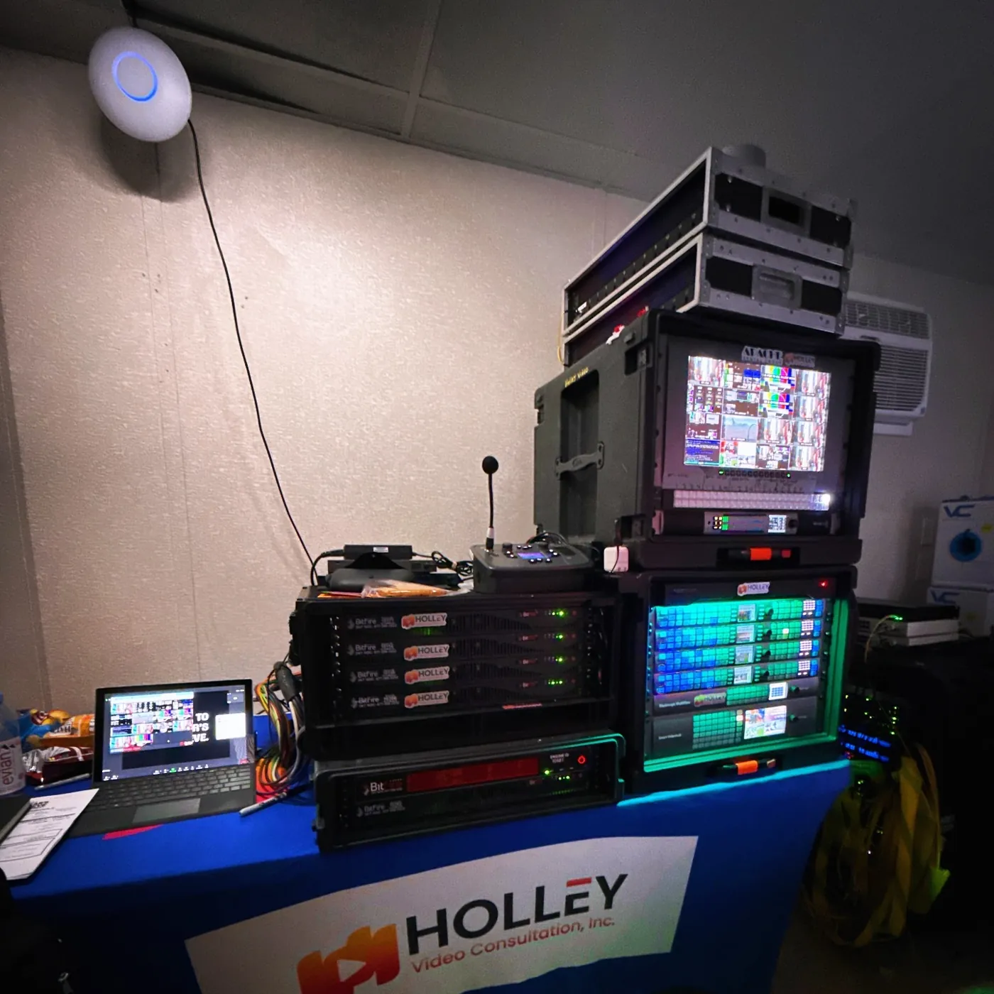 Holley Video rig on a branded table with monitors, routers and a laptop